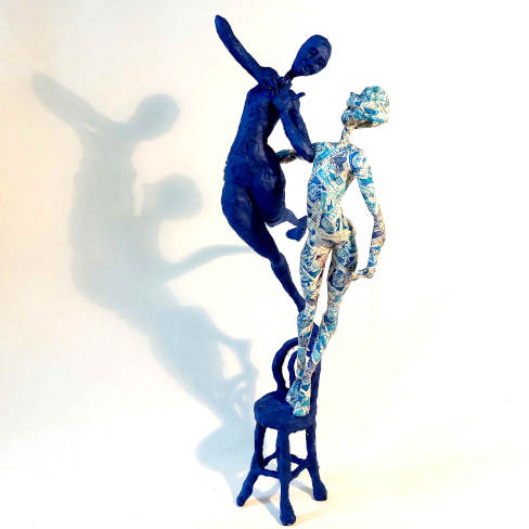 Sculpture de deux personnages debout sur une chaise entrelacée