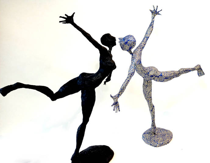 Deux personnages en mouvement, prêts à se rencontrer, l'un en papier noir, l'autre en papier bleu et doré